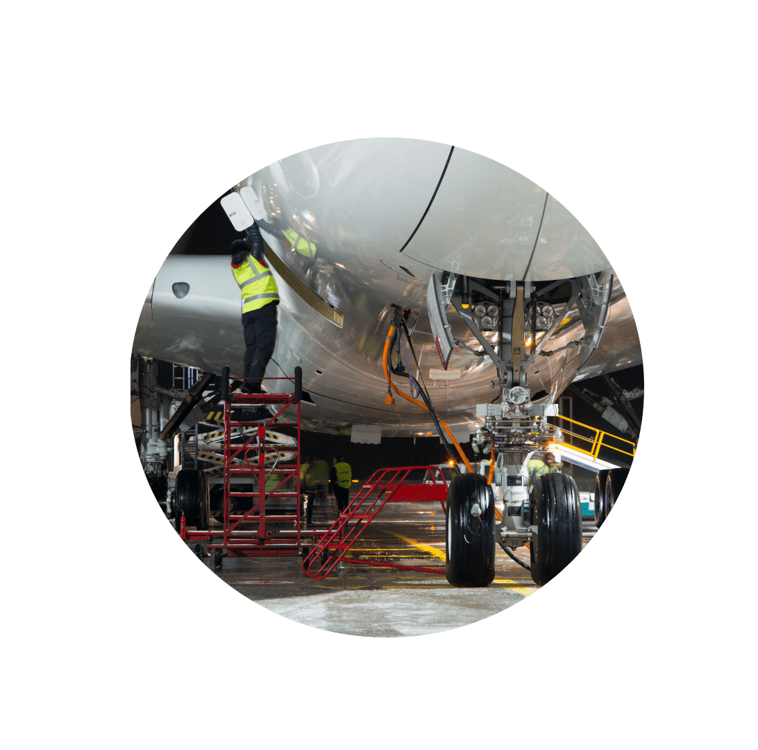 A man working on an airplane in the middle of a green circle.